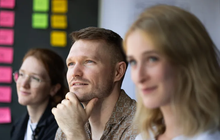 Work-in-progress Bild von drei Mitarbeitern.